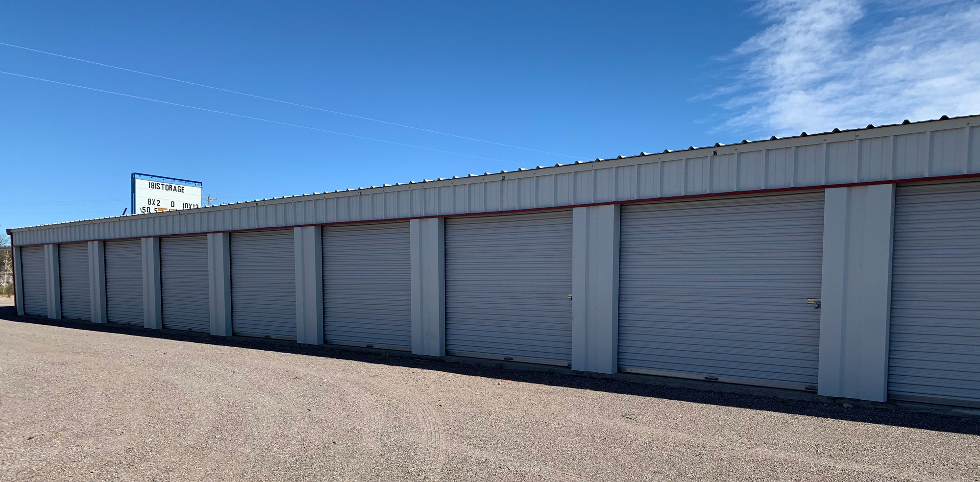 row of self storage units over a gravel parking area